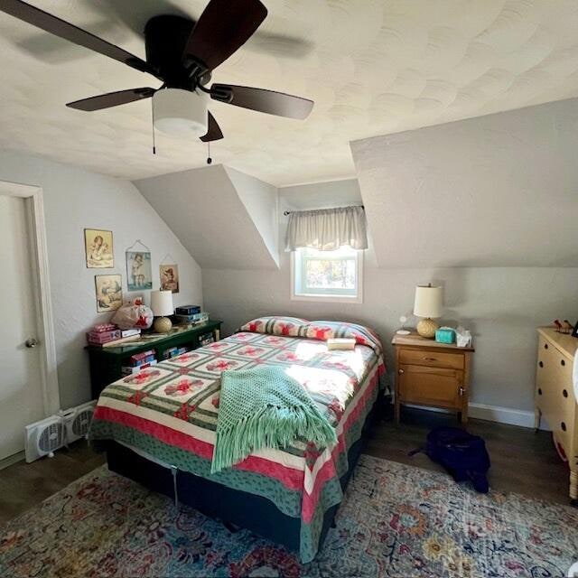 bedroom with dark hardwood / wood-style flooring, ceiling fan, and lofted ceiling