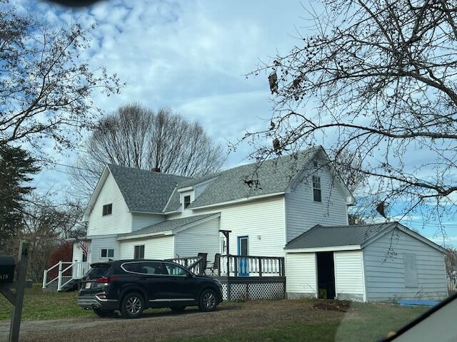 rear view of property featuring a garage and an outdoor structure