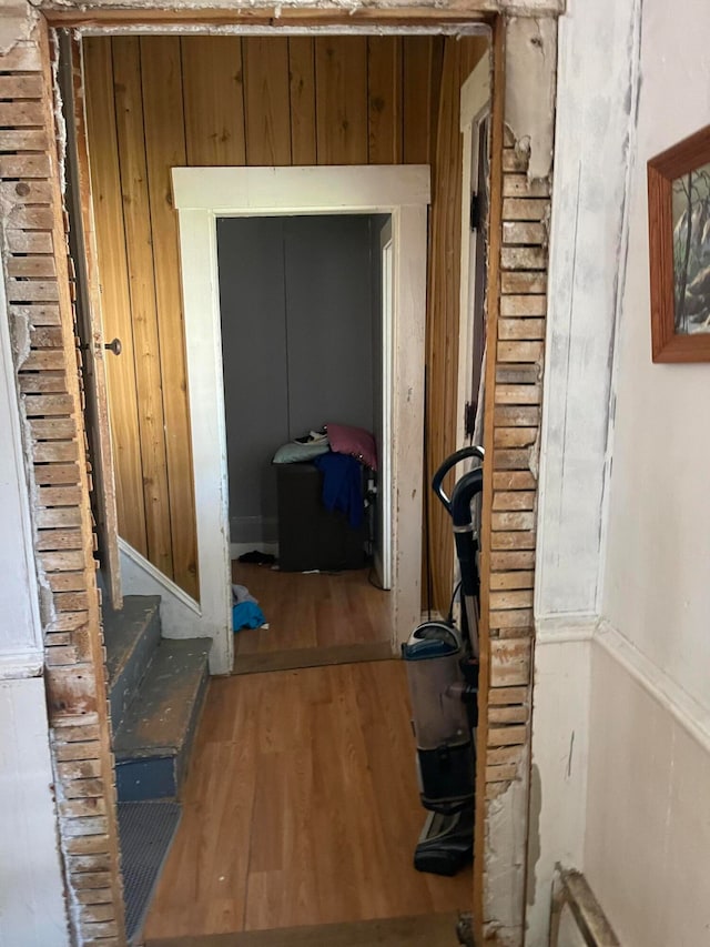 hallway featuring hardwood / wood-style floors and wood walls