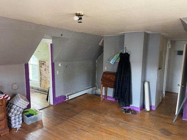 bonus room with lofted ceiling, baseboard heating, and wood-type flooring