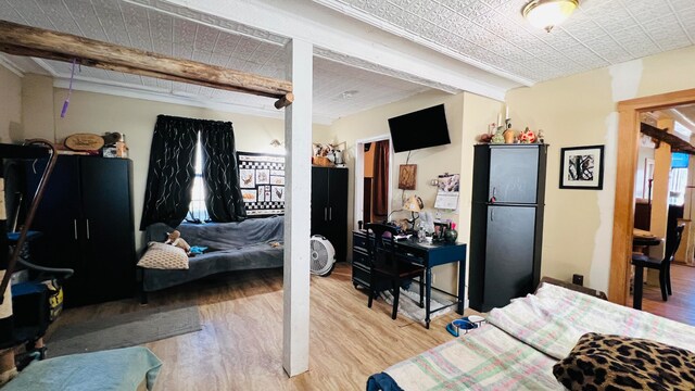 bedroom featuring beam ceiling and hardwood / wood-style flooring