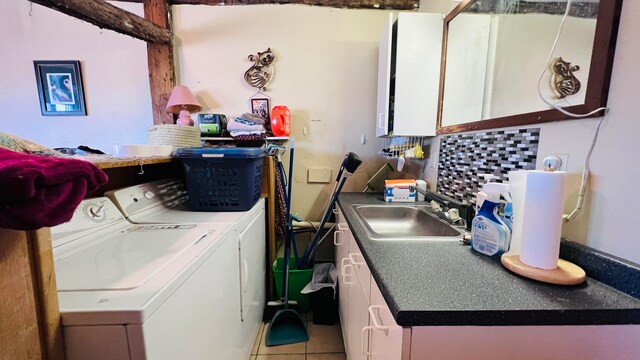 laundry area featuring independent washer and dryer, cabinets, sink, and tile patterned flooring