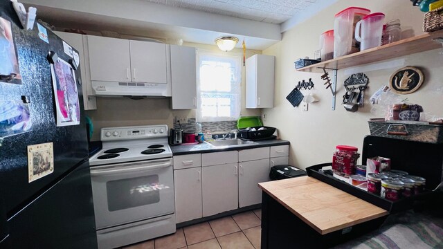 kitchen featuring sink, white range with electric cooktop, black fridge, white cabinets, and light tile patterned floors