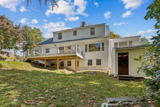 back of property with a yard and a deck