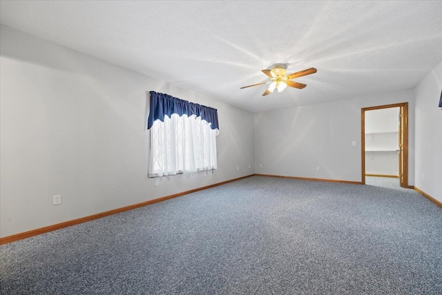 spare room with a ceiling fan, baseboards, carpet, and a textured ceiling