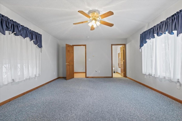 carpeted empty room featuring baseboards and ceiling fan