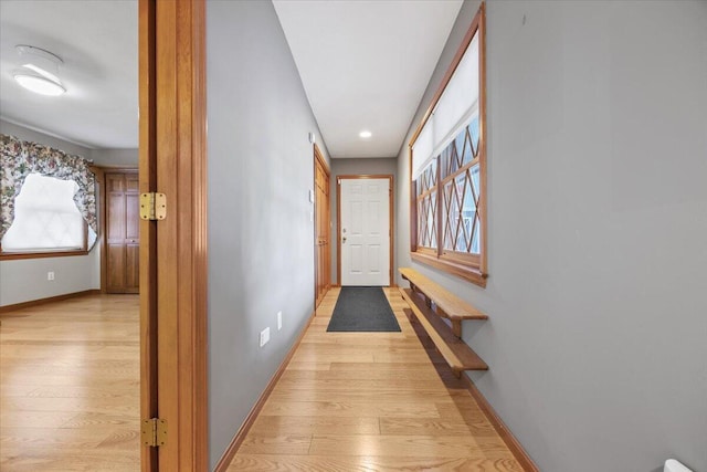 hall featuring baseboards, light wood-style floors, and recessed lighting