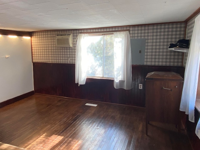 empty room featuring wood walls, electric panel, and dark hardwood / wood-style flooring