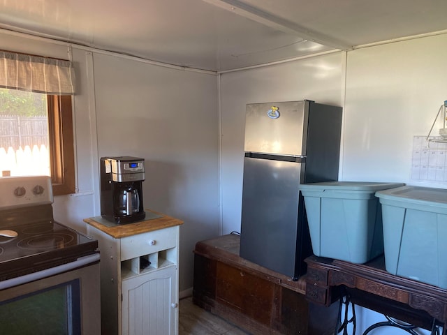 kitchen with stainless steel refrigerator and white range with electric cooktop