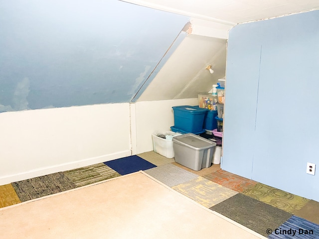 additional living space featuring lofted ceiling and light colored carpet