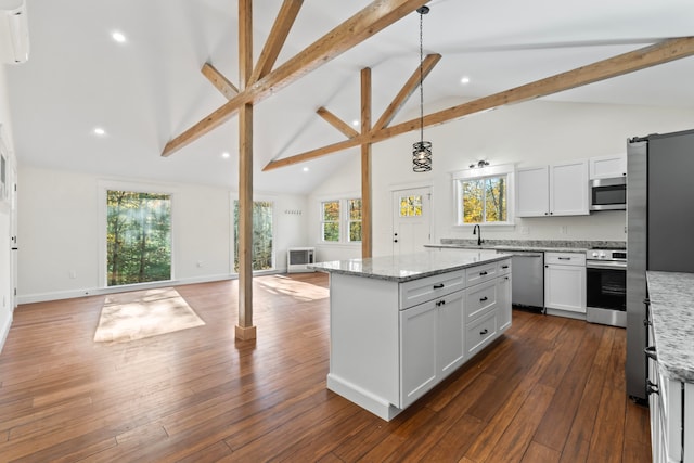 kitchen featuring beam ceiling, light stone counters, high vaulted ceiling, stainless steel appliances, and decorative light fixtures