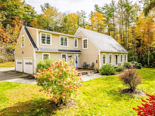 back of house featuring a wooden deck, a garage, and a lawn