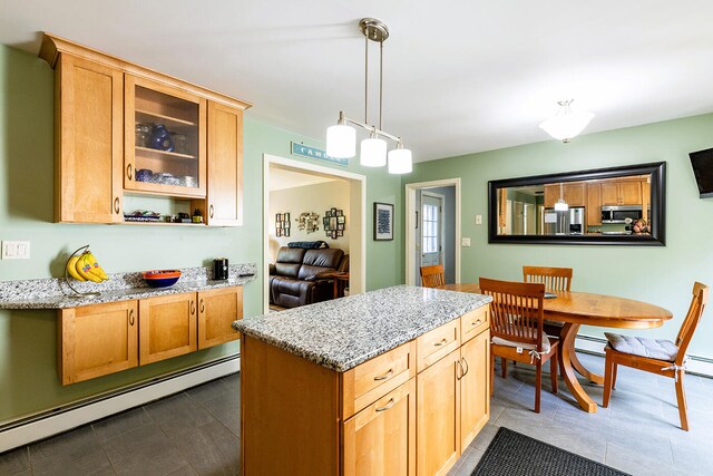 kitchen featuring baseboard heating, stainless steel appliances, light stone counters, and pendant lighting