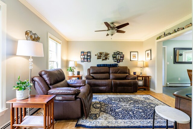 living room featuring light hardwood / wood-style floors, ornamental molding, a baseboard heating unit, and ceiling fan