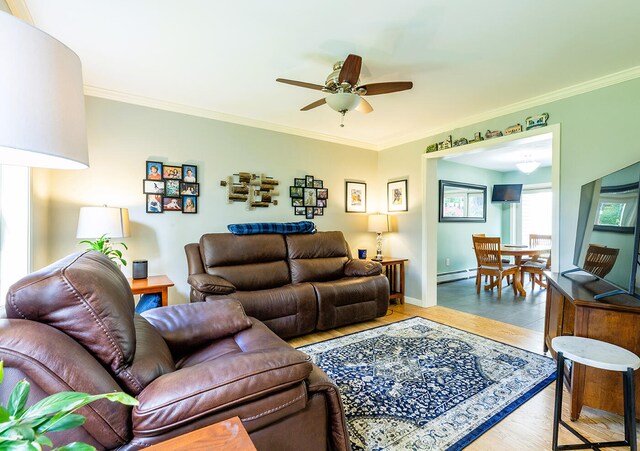 living room with crown molding, a baseboard heating unit, light wood-type flooring, and ceiling fan