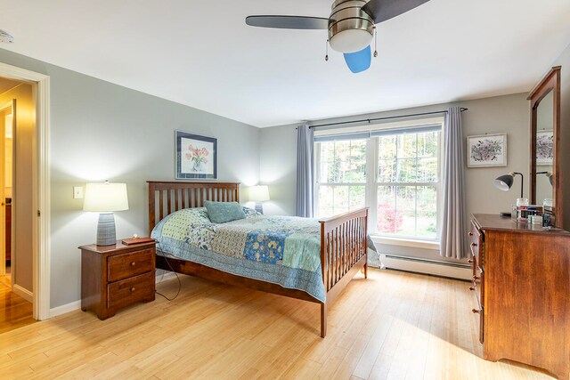 bedroom featuring light hardwood / wood-style floors, a baseboard radiator, and ceiling fan