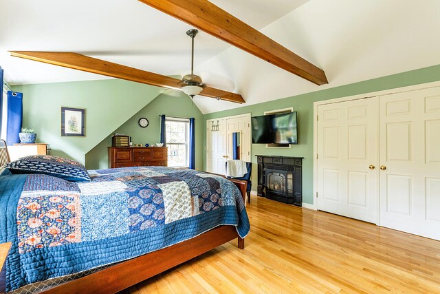 bedroom with lofted ceiling with beams, light hardwood / wood-style floors, and ceiling fan