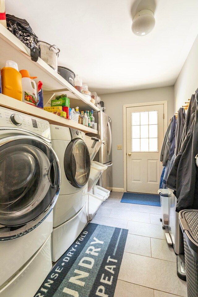 laundry room with washer and dryer and light tile patterned floors