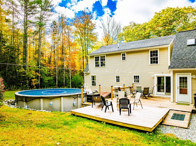 back of house featuring a deck and a lawn