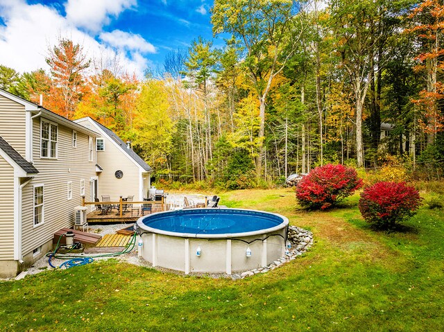 view of pool featuring a wooden deck and a lawn