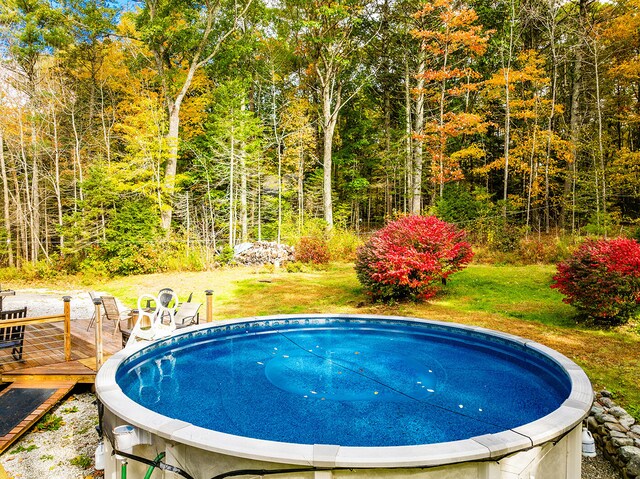 view of pool with a deck and a lawn