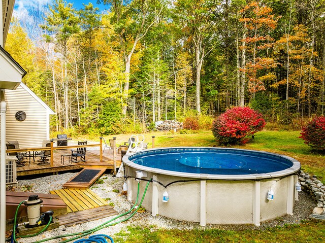 view of swimming pool featuring a wooden deck and a lawn