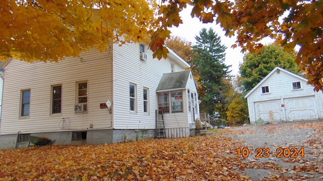 view of home's exterior with cooling unit, an outbuilding, and a garage