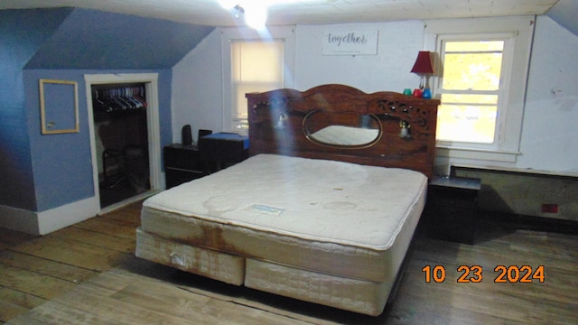 bedroom with lofted ceiling, hardwood / wood-style floors, and a closet