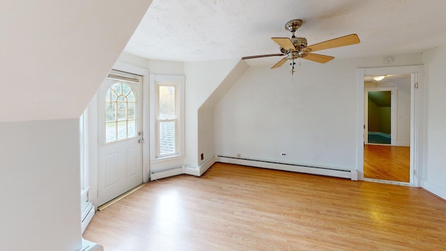 bonus room with light hardwood / wood-style floors, a baseboard heating unit, and ceiling fan