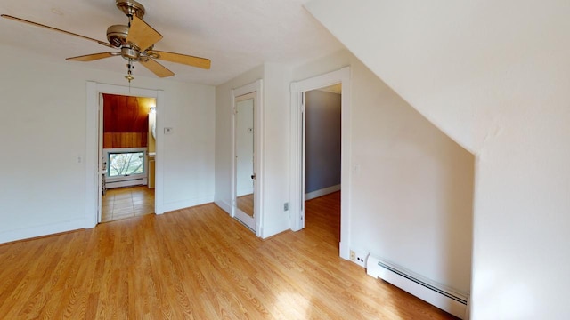 additional living space featuring baseboard heating, light wood-type flooring, and ceiling fan