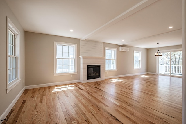 unfurnished living room featuring baseboards, light wood finished floors, and a notable chandelier