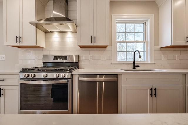 kitchen featuring light countertops, a sink, wall chimney exhaust hood, and stainless steel appliances