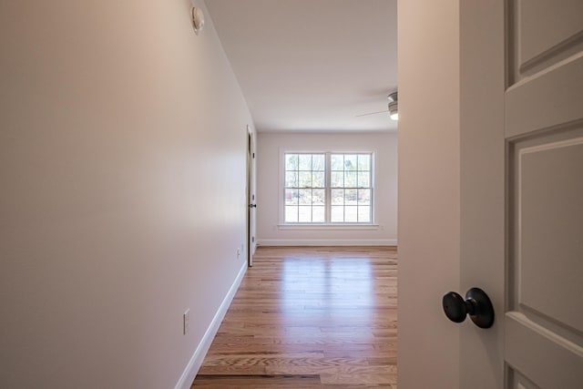 hall featuring baseboards and wood finished floors
