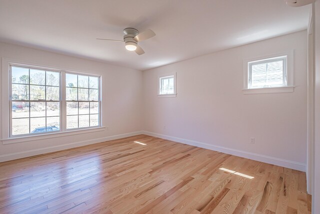 spare room with baseboards, ceiling fan, and light wood finished floors