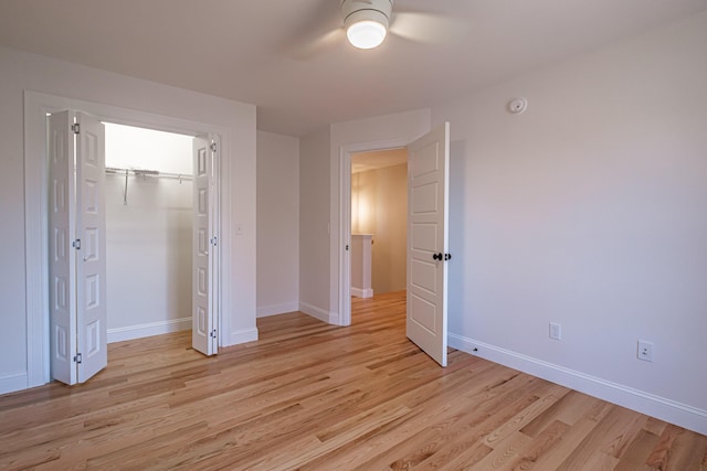 unfurnished bedroom with light wood-style floors, baseboards, ceiling fan, and a closet