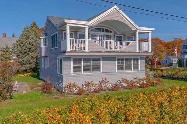 exterior space with a front lawn and a balcony