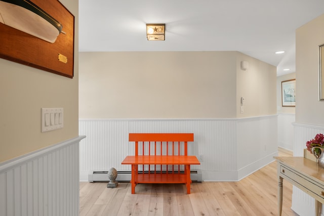 hall with baseboard heating and light wood-type flooring