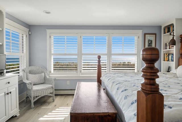 bedroom featuring light hardwood / wood-style flooring and a baseboard heating unit