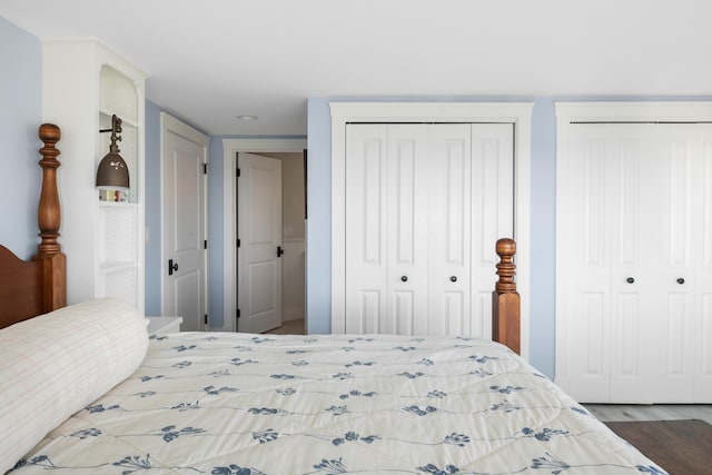 bedroom featuring dark hardwood / wood-style floors and two closets