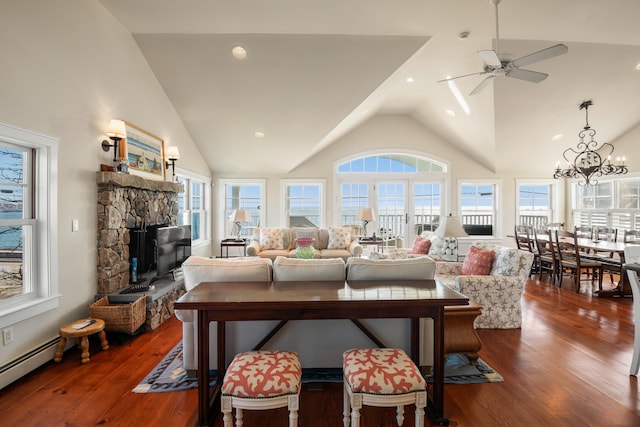 living room with dark hardwood / wood-style flooring, ceiling fan with notable chandelier, and a wealth of natural light