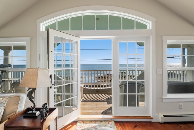 doorway to outside featuring baseboard heating, vaulted ceiling, a water view, and wood-type flooring