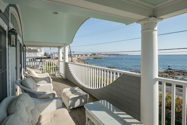 balcony featuring a view of the beach and a water view