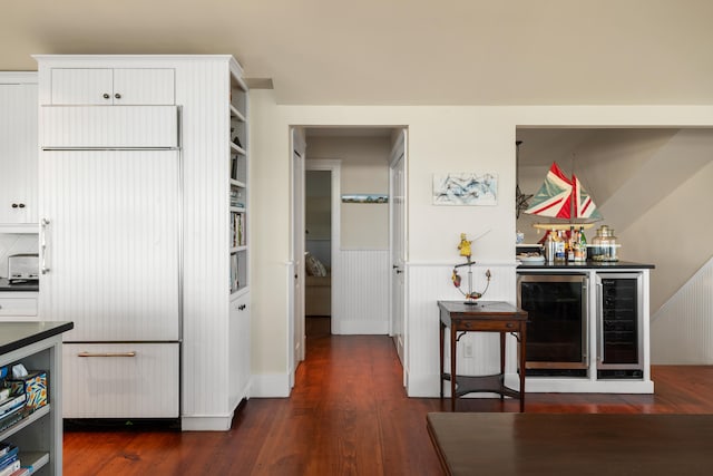 kitchen with white cabinets, beverage cooler, and dark wood-type flooring