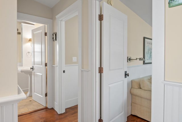 hallway with lofted ceiling and hardwood / wood-style floors