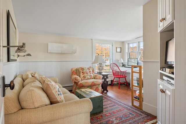 living room with hardwood / wood-style floors, a baseboard heating unit, and a wall mounted air conditioner