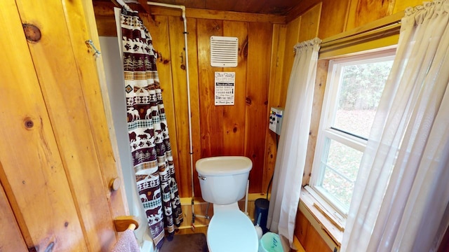 bathroom with toilet and wooden walls