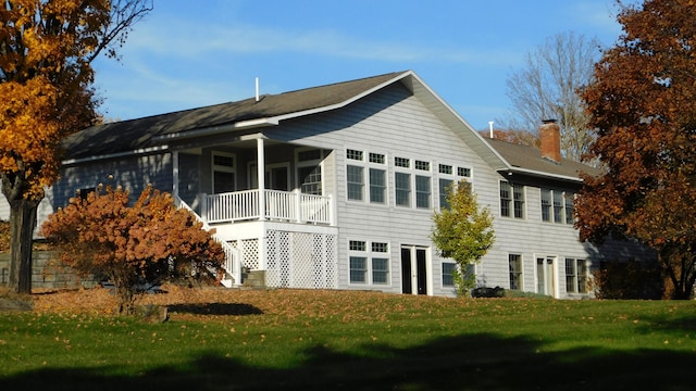 rear view of property with a yard