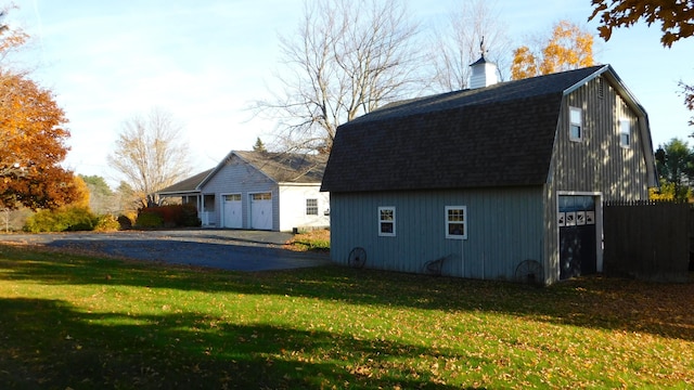 view of home's exterior with an outbuilding, a garage, and a yard