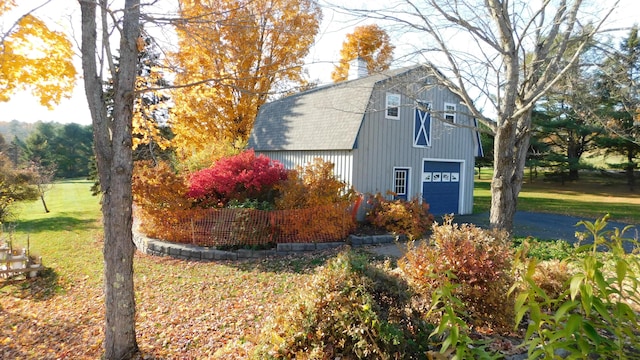 view of side of property with a garage and a lawn