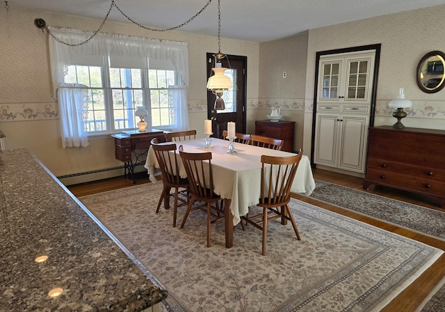 dining area with a baseboard heating unit and dark hardwood / wood-style flooring